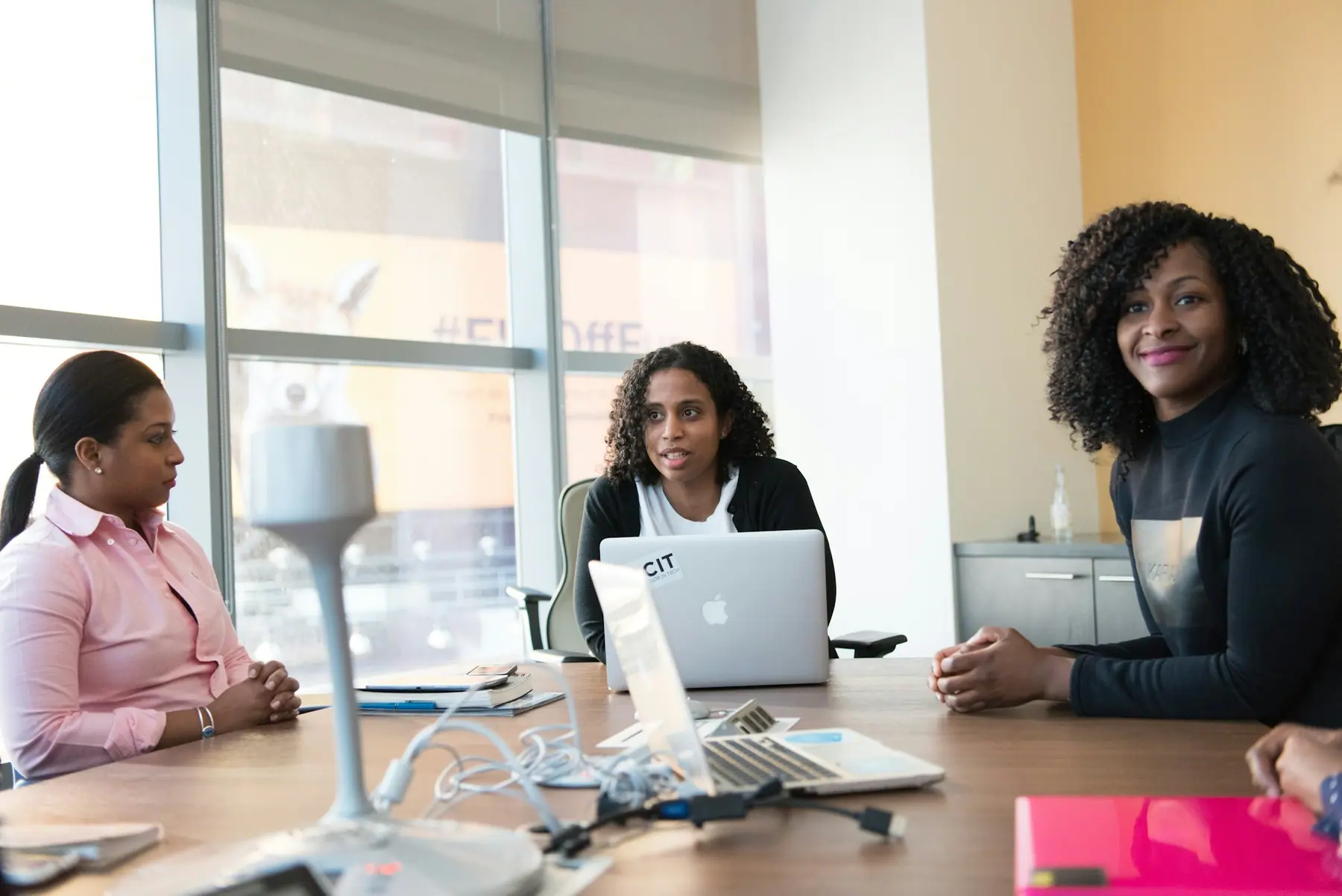 Small business team working together around a laptop in a bright office